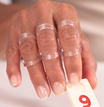 Close-up of a hand wearing clear Oval-8 Finger Splints on multiple fingers to support and align finger joints while maintaining full hand function.