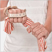 Hand wearing the 3pp Polycentric Hinged Ulnar Deviation Splint while gripping a towel, demonstrating support and alignment for fingers affected by ulnar drift.